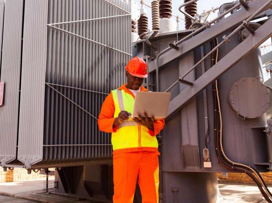professional african power company technical worker using laptop computer - Transformer Dispatch and Delivery